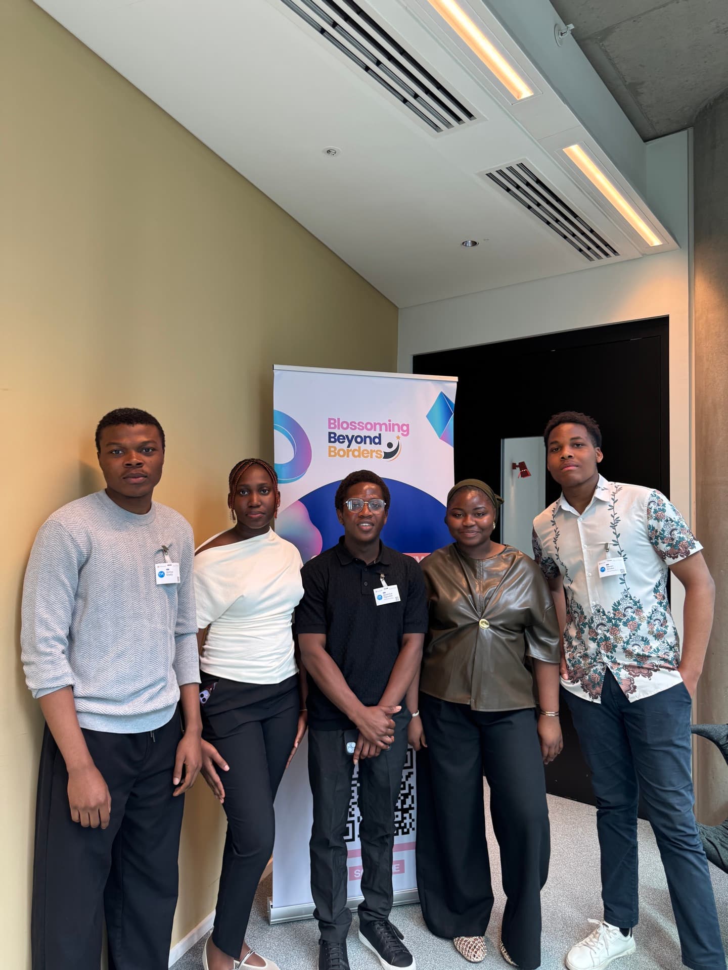 BBB founders and volunteers standing together by the Blossoming Beyond Borders banner